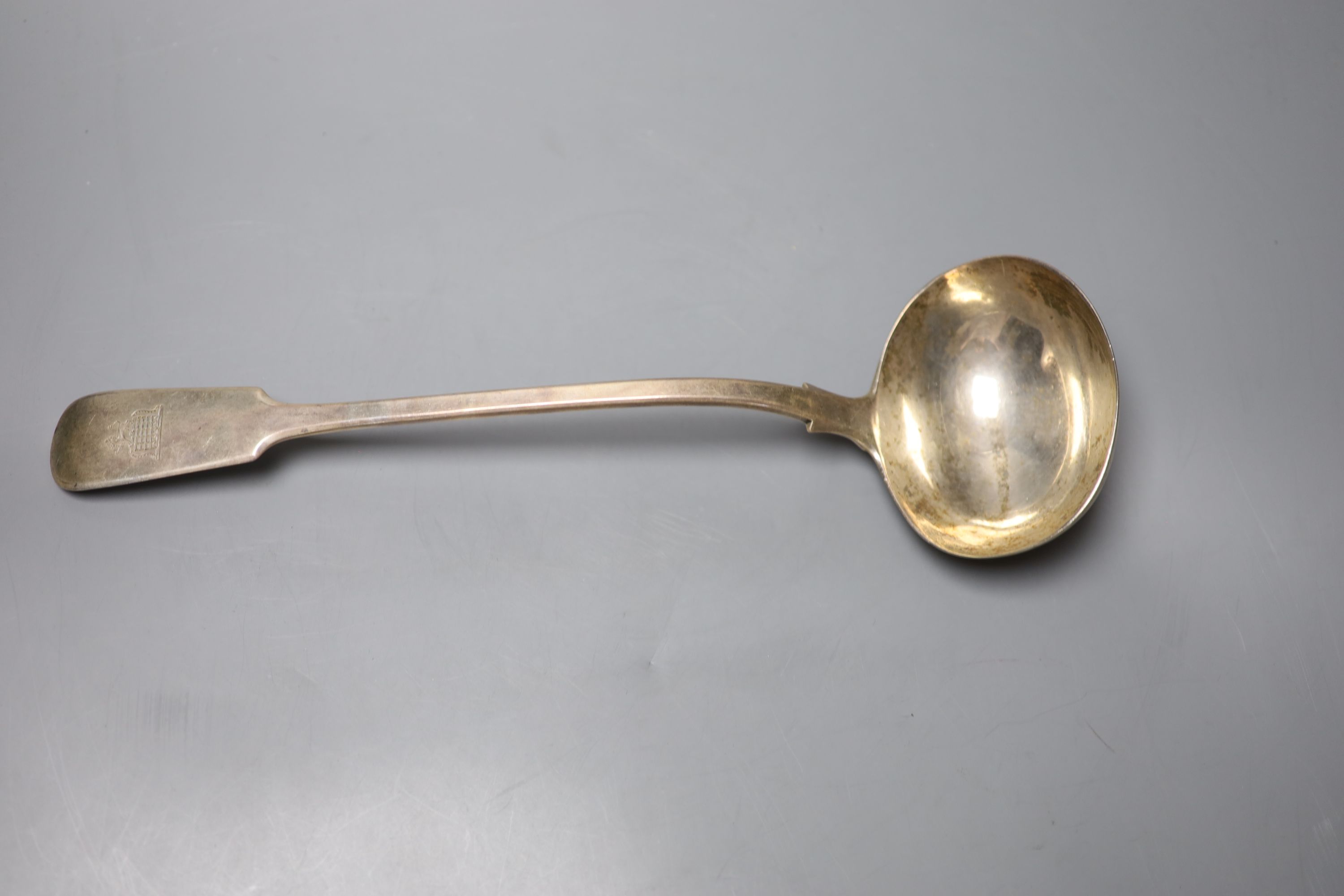 A Victorian silver fiddle pattern soup ladle, with engraved crest, William Smily, London 1862, 34.2cm, 9oz.